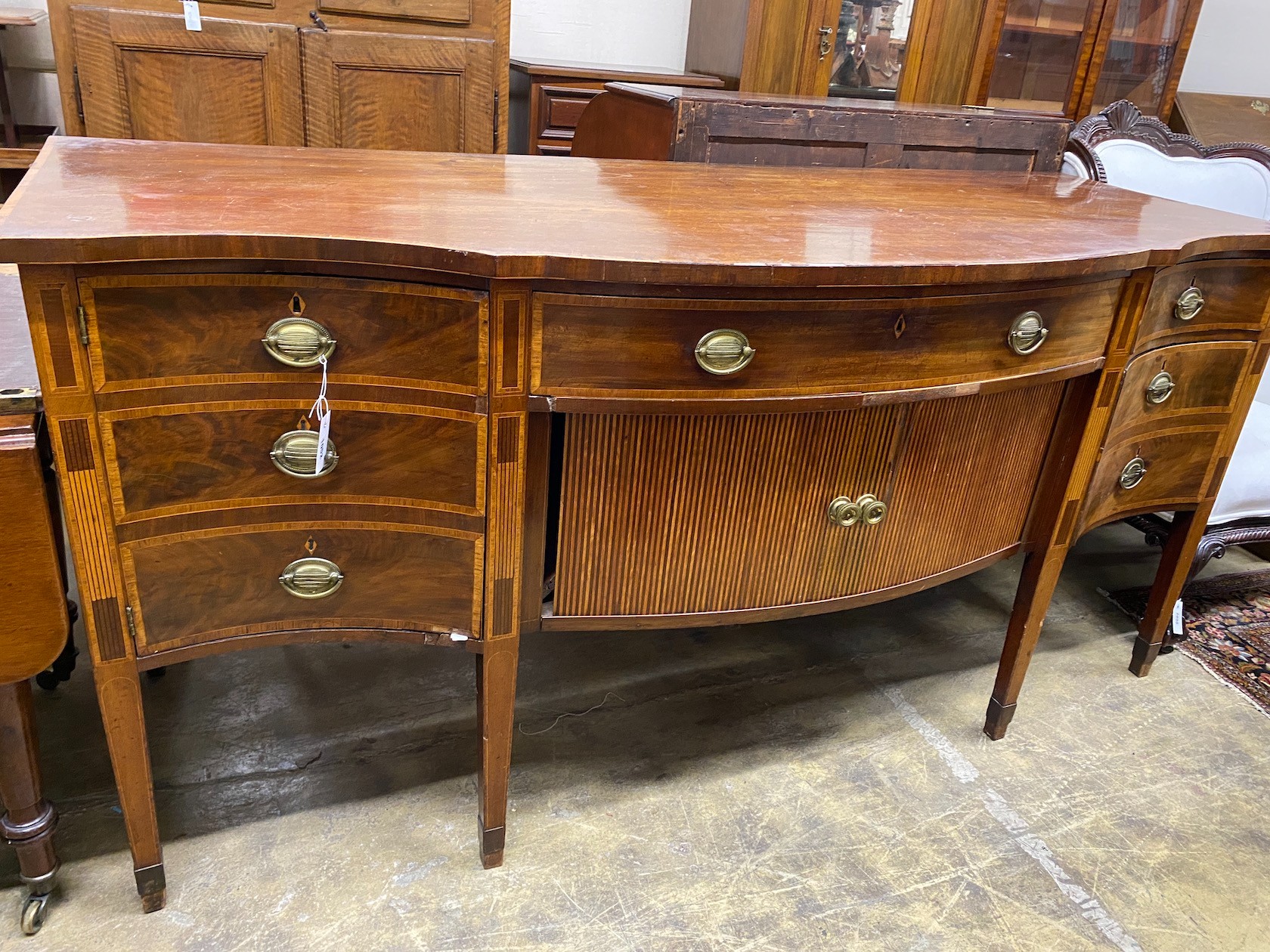 A George III satinwood banded mahogany serpentine sideboard with central tambour compartment width 199cm, depth 80cm height 95cm